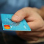 a picture of a mastercard being showed in order or as a reference for ach payment processings and rejections